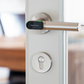The Tapkey door handle on a white door.